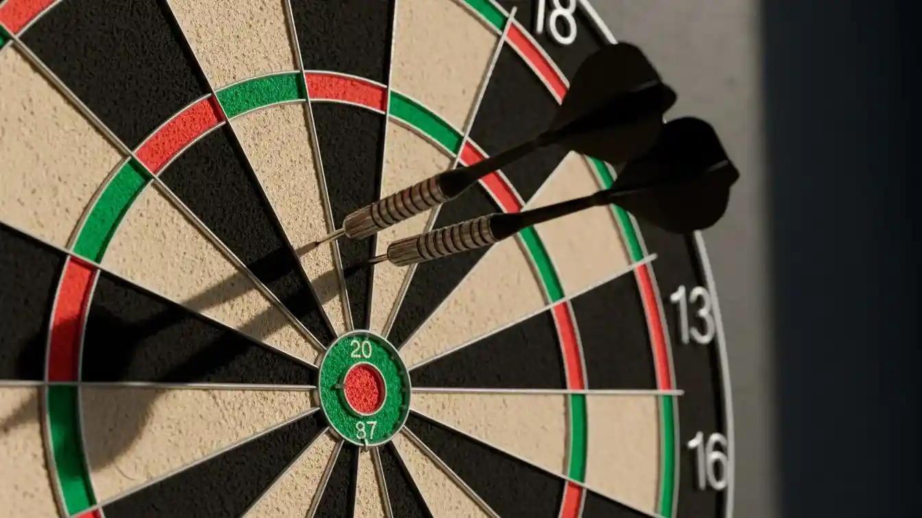 Nahaufnahme einer Dartscheibe mit Triple-20-Feld und drei Darts im Board